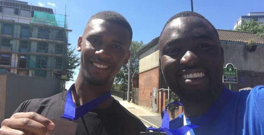 Nathan Longe and Uche Monago smiling after completing a 10k charity run with their medals